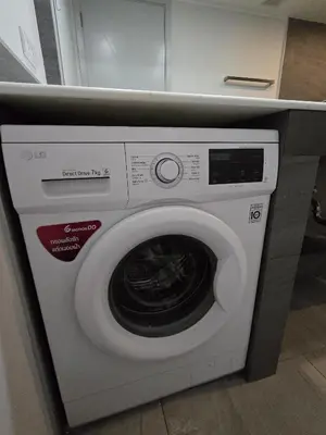 a white washing machine sitting under a counter at Easy Stay – 2-Bedroom T2-618 in Phuket Town