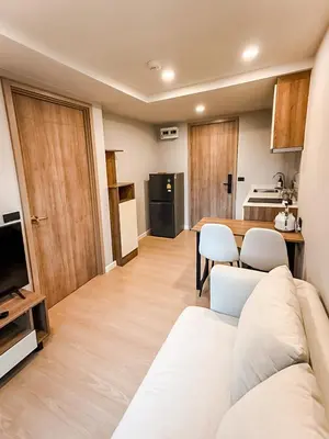 a living room with a white couch and a kitchen at New Stylish Cozy One-bedroom Apartment in Bangtao, Phuket, Near EDC in Ban Thalat Choeng Thale