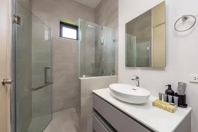 a bathroom with a sink and a glass shower at Villa Noa Modern 2-Bedroom with Private Pool in Rawai Beach