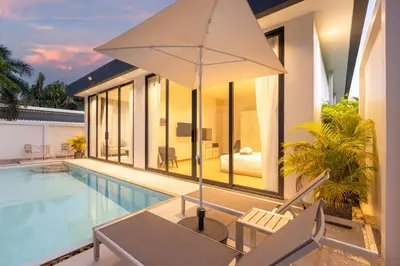 a villa with a swimming pool and an umbrella at Villa Noa Modern 2-Bedroom with Private Pool in Rawai Beach