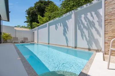 a swimming pool in a house with glass walls at Villa Noa Modern 2-Bedroom with Private Pool in Rawai Beach