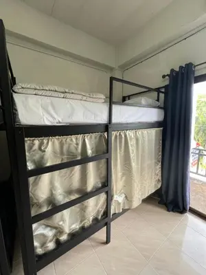 two bunk beds in a room with a window at Klong Muang Hostel คลองม่วงโฮสเทล in Ban Ko Kwang