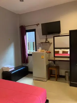 a room with a refrigerator and a table and a mirror at Saiinam Laguna Inn in Ban Thalat Choeng Thale