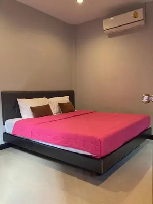 a bedroom with a large bed with a red blanket at Saiinam Laguna Inn in Ban Thalat Choeng Thale