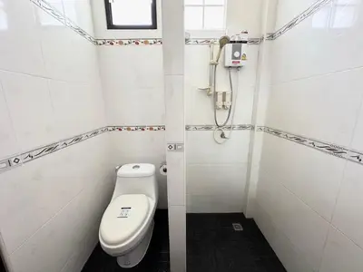 a small bathroom with a toilet and a shower at Saiinam Laguna Inn in Ban Thalat Choeng Thale
