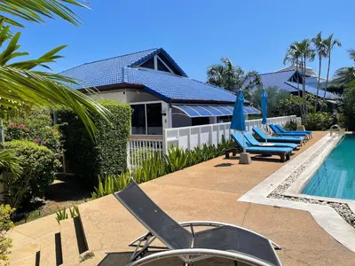 a swimming pool with lounge chairs and a house at Villa Jasmine in Rawai Beach
