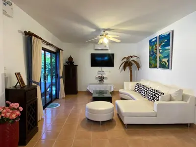a living room with white furniture and a ceiling fan at Villa Jasmine in Rawai Beach