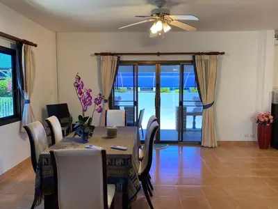 a dining room with a table and a ceiling fan at Villa Jasmine in Rawai Beach