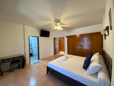 a bedroom with a bed with a ceiling fan at Villa Jasmine in Rawai Beach