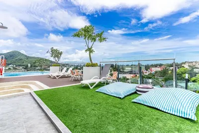 a patio with grass and chairs and a pool at Fantasea by Villacarte in Kamala Beach