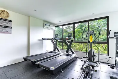 a room with a gym with a treadmill and a window at Fantasea by Villacarte in Kamala Beach