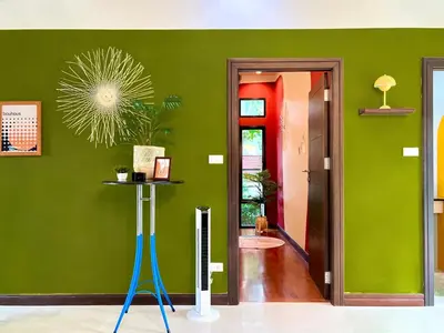 a room with a green wall with a blue stand in it at MYSA House Pool Villa Central Phuket in Phuket