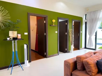 a living room with green walls and a couch at MYSA House Pool Villa Central Phuket in Phuket