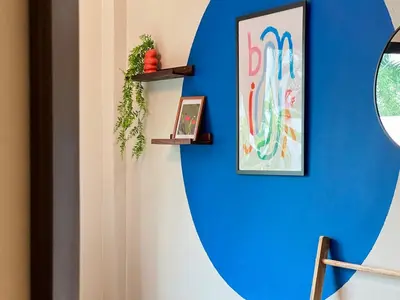a blue wall with a mirror and a picture on it at MYSA House Pool Villa Central Phuket in Phuket