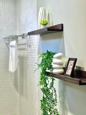 a shelf with plants and towels on a wall at MYSA House Pool Villa Central Phuket in Phuket