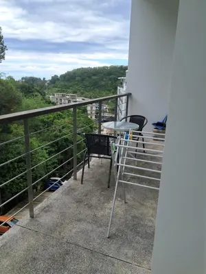 a balcony with chairs and a table on a building at Kamala falls seaview 1 bedroom in Phuket Town