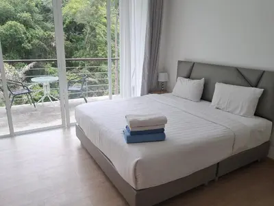 a bedroom with a bed with a large window at Kamala falls seaview 1 bedroom in Phuket Town