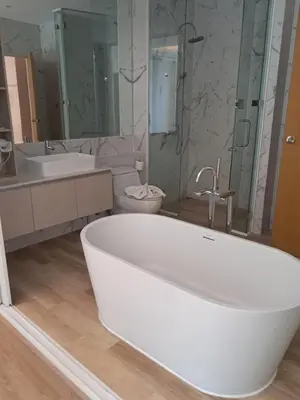 a white bathroom with a tub and a toilet at Kamala falls seaview 1 bedroom in Phuket Town