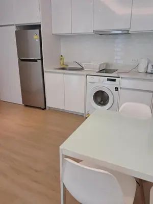 a kitchen with a refrigerator and a washing machine at Kamala falls seaview 1 bedroom in Phuket Town
