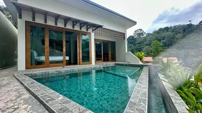 a swimming pool in front of a house at Villa avec piscine privée in Kamala Beach