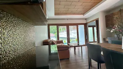a living room with a couch and a table at Villa avec piscine privée in Kamala Beach