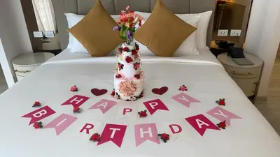 a bed with hearts and a vase of flowers on it at Villa Atchara in Patong Beach
