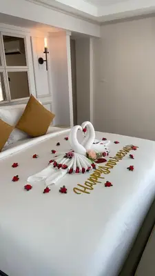 two swans sitting on top of a bed with flowers at Villa Atchara in Patong Beach