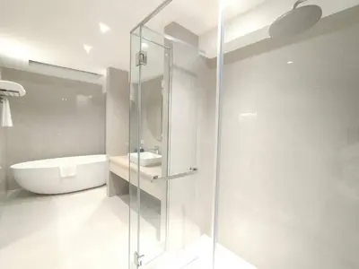 a bathroom with a glass shower and a tub and a sink at Villa Atchara in Patong Beach