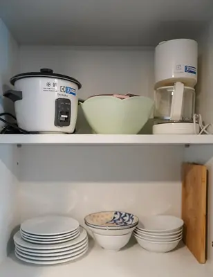 a kitchen shelf with plates and bowls and a appliance at 1 bedroom Mida Grande Resort, Phuket in Surin Beach