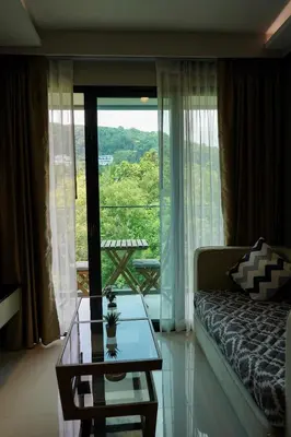 a living room with a couch and a glass table at 1 bedroom Mida Grande Resort, Phuket in Surin Beach