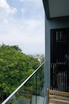 a balcony with a bench and a view of trees at 1 bedroom Mida Grande Resort, Phuket in Surin Beach