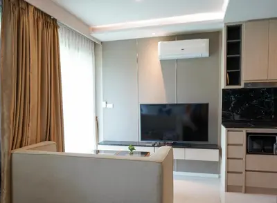 a living room with a tv and a couch in a room at 1 bedroom Mida Grande Resort, Phuket in Surin Beach