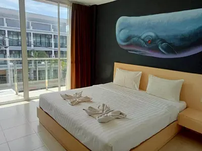 a bedroom with a bed with a whale painting on the wall at XX GO INN Aonang Beach - หาดอ่าวนาง กระบี่ in Ban Khlong Haeng