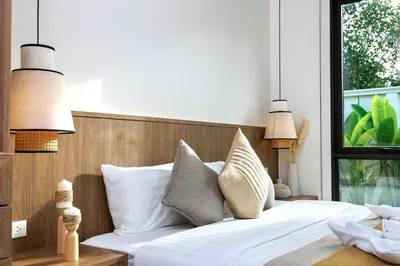 a bedroom with a bed with white sheets and pillows at Lerka Villa Elegant 3 Bedroom in Rawai Beach