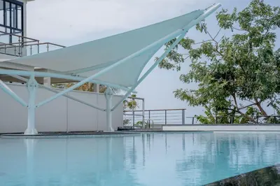 a swimming pool with a white canopy and trees at Utopia Karon - Karon Beach in Karon Beach