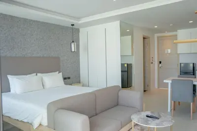a bedroom with a bed and a couch and a kitchen at Utopia Karon - Karon Beach in Karon Beach