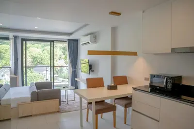a kitchen and living room with a bed and a table at Utopia Karon - Karon Beach in Karon Beach