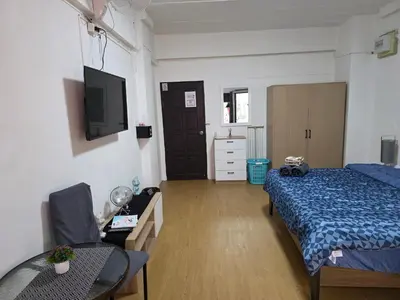 a bedroom with a bed and a table and a tv at Monkey Apartment 3 in Patong Beach