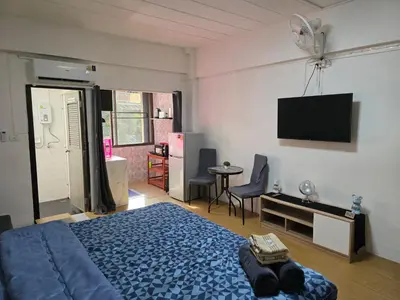 a bedroom with a blue bed and a flat screen tv at Monkey Apartment 3 in Patong Beach