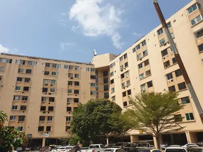 a large building with cars parked in a parking lot at Monkey Apartment 3 in Patong Beach