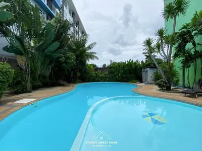 a large blue swimming pool in front of a building at THe bell chalong phuket 19 in Ban Klang