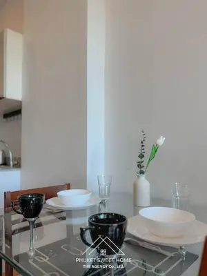 a glass table with plates and bowls on it at THe bell chalong phuket 19 in Ban Klang