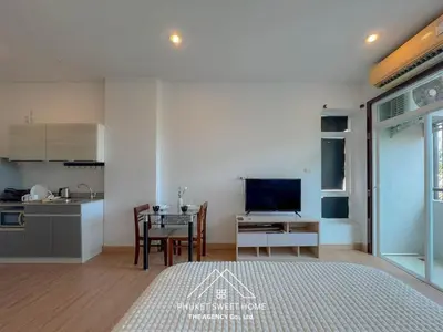 a living room with a table and a kitchen at THe bell chalong phuket 19 in Ban Klang