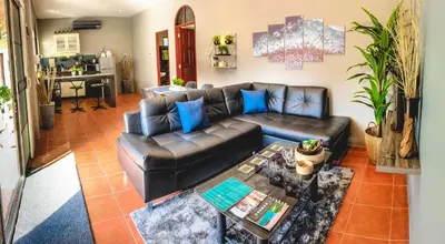 a living room with a leather couch and a table at Serenity Holiday Pool Villa, Bangtao Beach in Surin Beach