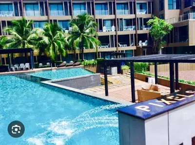 a swimming pool in front of a building at Phuket, The Pixcel Cape Panwa Condo in Ban Ao Makham