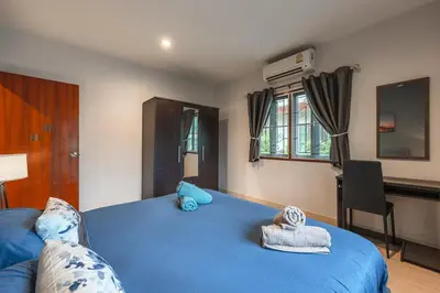 a bedroom with a blue bed with towels on it at Coastline Pearl Holiday Home, Bangtao Beach in Ban Thalat Choeng Thale