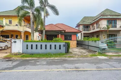 a house with a fence in front of a street at Coastline Pearl Holiday Home, Bangtao Beach in Ban Thalat Choeng Thale