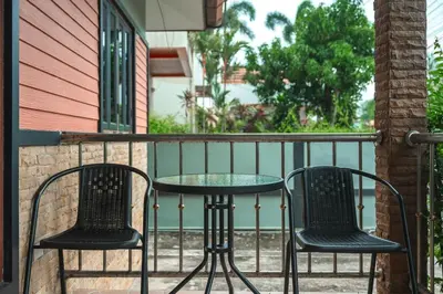 two chairs and a table on a balcony at Coastline Pearl Holiday Home, Bangtao Beach in Ban Thalat Choeng Thale