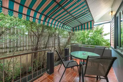 a patio with a table and chairs on a balcony at Coastline Pearl Holiday Home, Bangtao Beach in Ban Thalat Choeng Thale