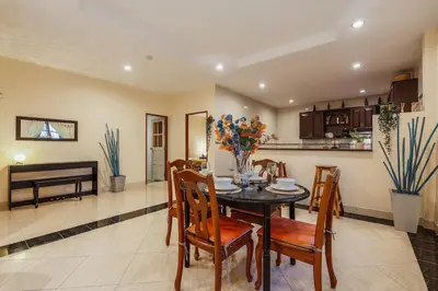 a dining room and kitchen with a table and chairs at Areca Holiday Home 1, Bangtao Beach in Ban Thalat Choeng Thale